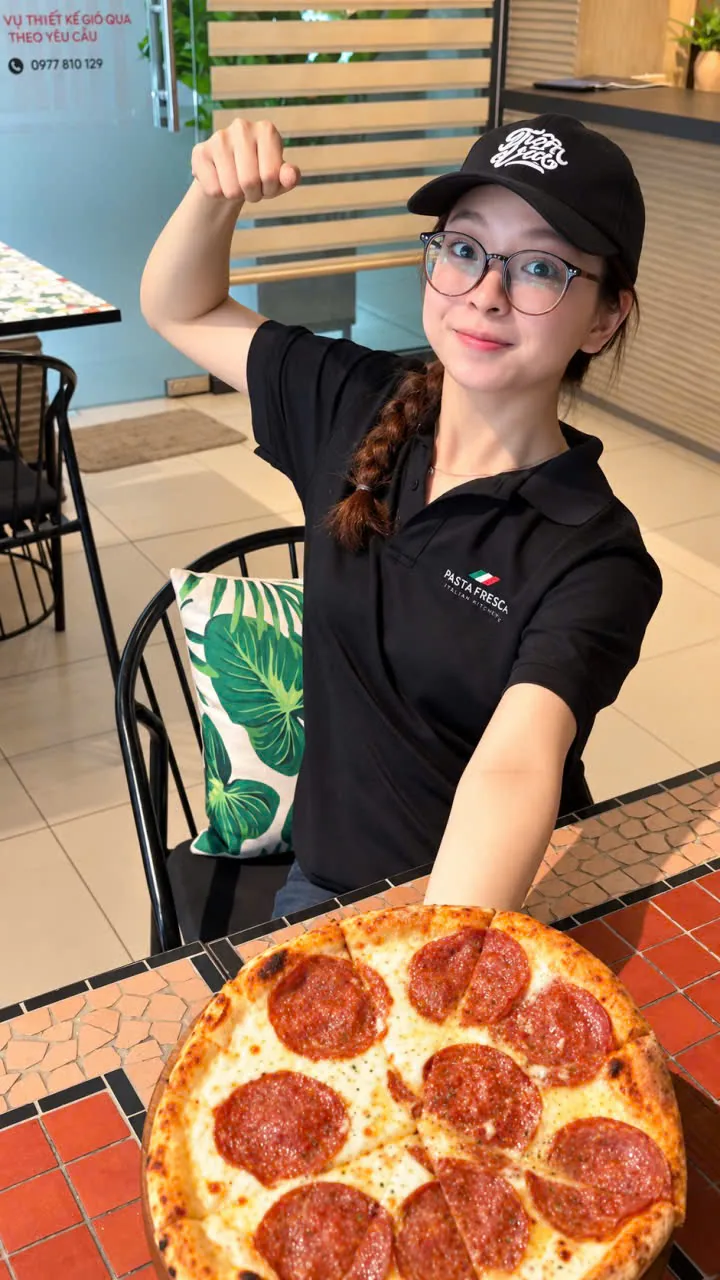 A Pasta Fresca team member with a pizza