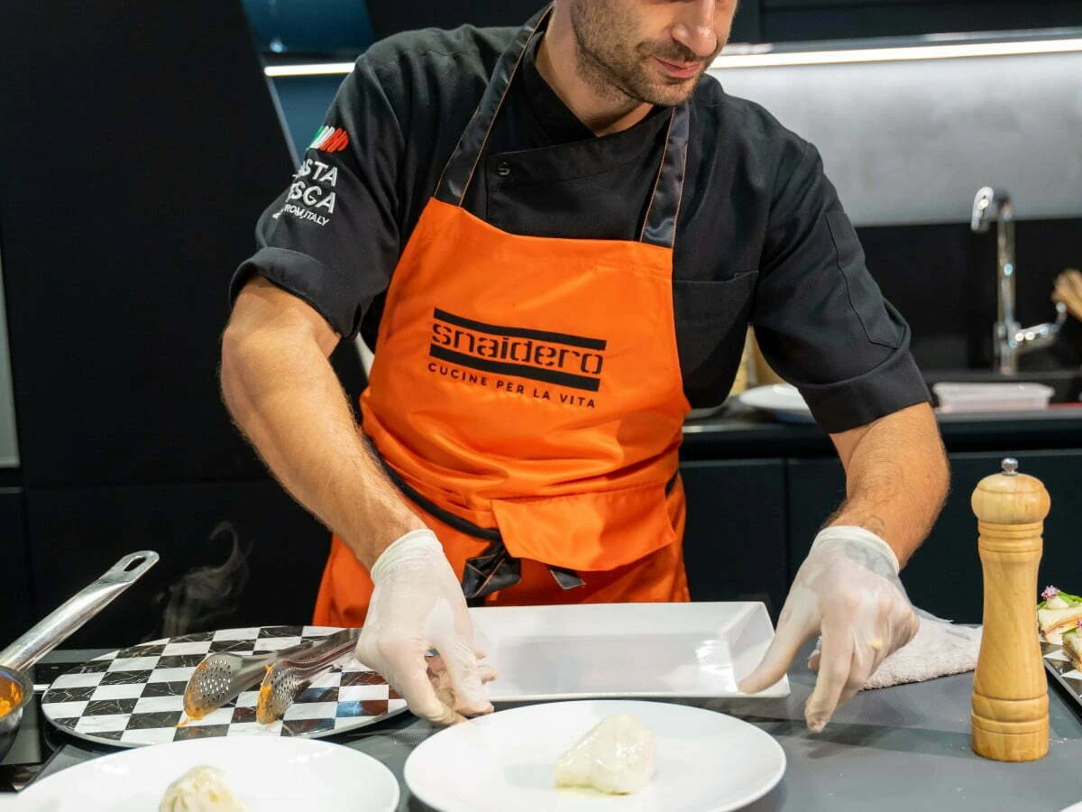 A Pasta Fresca chef finishing dishes at an event