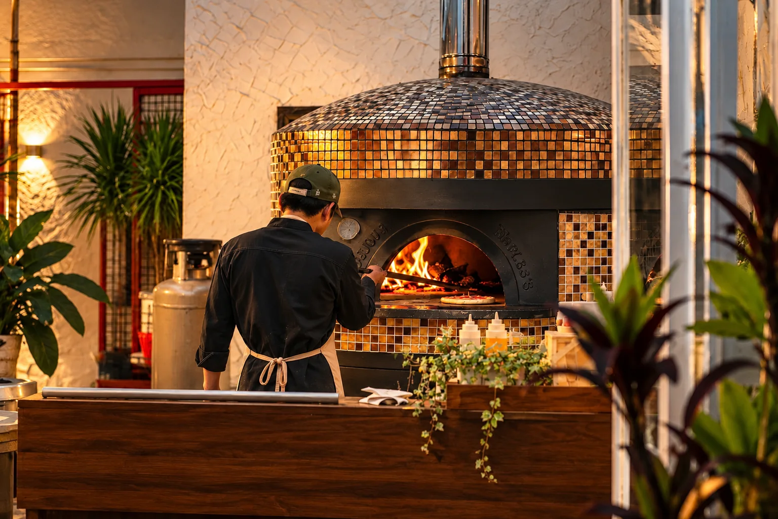 Pasta Fresca chef beside the wood-fired pizza oven